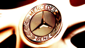 特寫：汽車輪圈上的 Mercedes-Benz 標誌，帶有金色燈光。 — Mercedes-Benz 壁紙