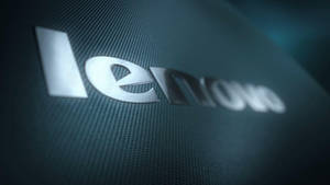 時尚的銀色 Lenovo 標誌，位於帶有紋理的深藍綠色表面上。