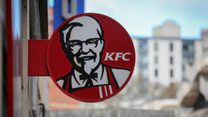 KFC標誌招牌，桑德斯上校的臉安裝在城市的柱子上。 — 肯德基 壁紙