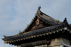 傳統日本寺廟屋頂，彎曲屋簷和裝飾瓦片，在陰雲天空下。 — 東京鐵塔 壁紙