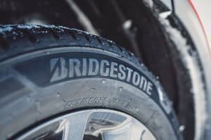 帶有 Bridgestone 品牌標誌的積雪汽車輪胎特寫。 — 弗萊克斯·惠勒 壁紙