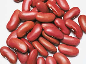 光澤的紅腰豆堆積在白色表面上。 — 4:3 壁紙