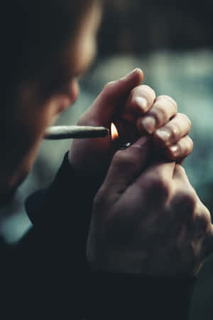 一個人在昏暗光線下用打火機點燃香煙。 — 小米平板 8 壁紙