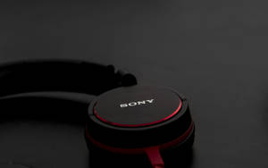 黑色Sony耳機，紅色邊框，深色背景。 — Sony 壁紙