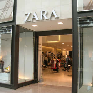 Zara服裝店入口，設有玻璃門和內部的購物者。 — Zara 壁紙