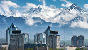 藍天下背景有雪山的城市建築 — 山脈 壁紙