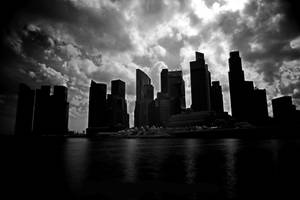 城市天際線剪影，摩天大樓在暴風雨的天空下倒映在水中。