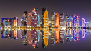 夜晚城市天際線，摩天大樓倒映在水中。 — 卡達 壁紙