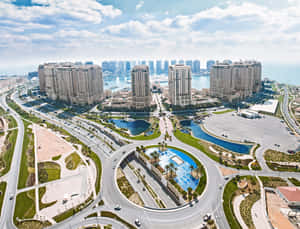 現代沿海城市的鳥瞰圖，有彎曲的高速公路和高層建築。 — 卡達 壁紙