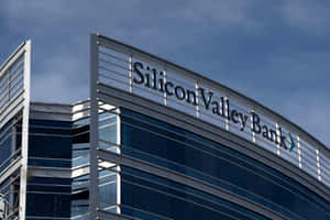 Silicon Valley Bank 建築，玻璃外牆，藍天背景。 — MacBook Pro 14 壁紙