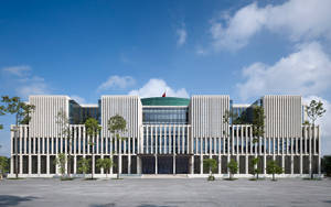 現代白色建築，帶有垂直條紋和玻璃幕牆，在藍天下。 — 唐人街 壁紙