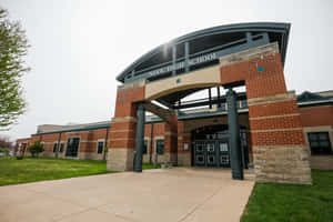 Nixa High School 磚砌建築入口，拱形簷篷，綠草坪。 — 教育 壁紙