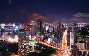 燈光明亮、道路繁忙的夜景城市。 — 城市燈光 壁紙