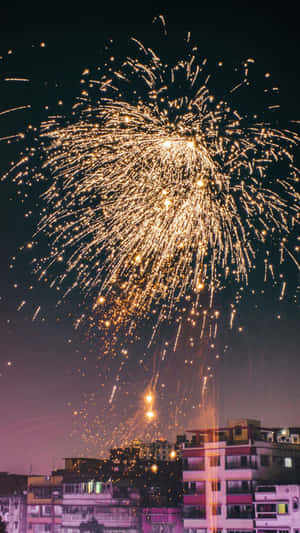 金色煙火在夜間的城市天際線上綻放。 — 新年快樂 壁紙