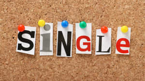 拼出SINGLE的彩色紙字母，用大頭針固定在軟木板上。 — 單身 壁紙