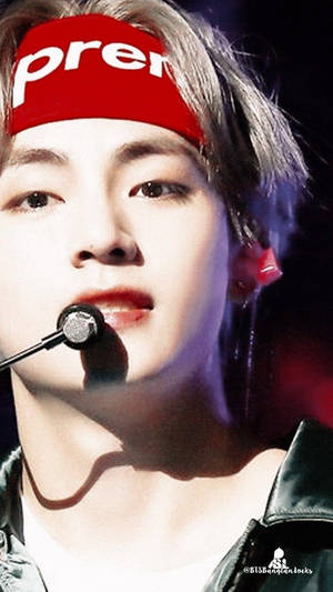 K-pop表演者在舞台上戴著紅色頭帶和黑色外套。 — 三宅隆 壁紙
