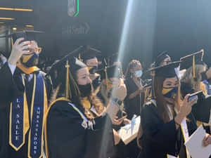 學生穿著畢業袍和方帽在典禮上自拍。 — 畢業 壁紙