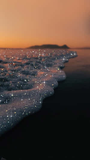 日落時分，海浪在黑暗的海灘上閃爍星光。 — 海灘度假 壁紙