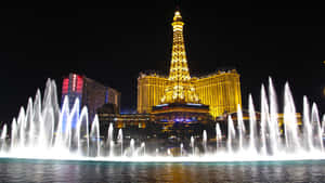 拉斯維加斯夜晚的金色艾菲爾鐵塔複製品和舞動的噴泉。 — 拉斯維加斯之夜 壁紙