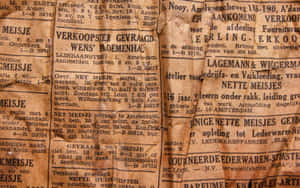 舊荷蘭報紙頁面的特寫，文字褪色，紙張發黃。 — Old Paper 壁紙