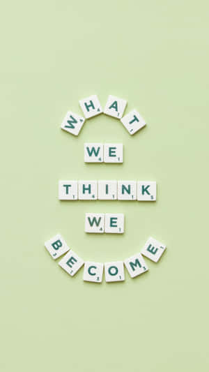 Scrabble 字母牌排列在綠色背景上拼出「What we think we become」。 — 語錄 壁紙