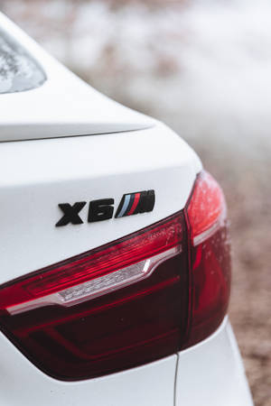 被雪覆蓋的白色BMW X6M後方徽章和尾燈。 — Mercedes Benz C300 壁紙