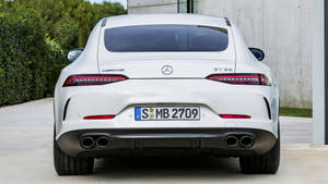 白色Mercedes-AMG GT S跑車停放在戶外，靠近綠化和現代建築。 — Mercedes Benz C300 壁紙