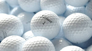 一堆帶有凹坑紋理的白色Titleist高爾夫球。 — 16:9 壁紙