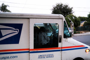 住宅區街道上，USPS送貨車司機穿著格子襯衫。 — 卡車 壁紙