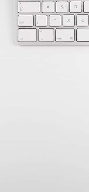 淺灰色表面上白色電腦鍵盤的特寫。 — iPhone 15 Plus 壁紙