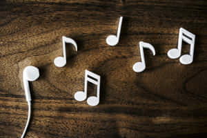 深色木質表面上的白色音符和耳塞。 — 音樂錄影帶 壁紙