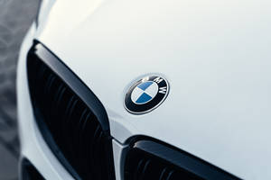 白色引擎蓋上黑色格柵旁的寶馬標誌特寫。 — Mercedes-Benz 壁紙