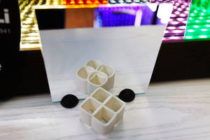 白色幾何3D列印物體和黑色蓋子放在木質表面上，鏡子中反射出多彩的LED燈光。 — 藝術 壁紙