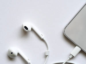 白色耳機和電話在白色表面上。 — 冬季美學 壁紙