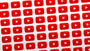 紅色 YouTube 播放按鈕以重複網格圖案排列在白色背景上。 — YouTube 標誌 壁紙