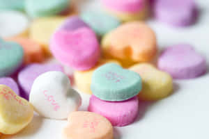 色彩繽紛的心形糖果，上面有 love 和 call me 等甜蜜訊息。 — 糖果 壁紙