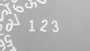 白色數字散落在灰色紋理背景上，123 居中。 — 高解析度 壁紙