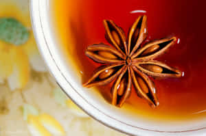 八角漂浮在帶有花卉背景的熱茶杯中。 — 茶園 壁紙