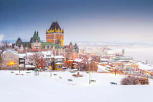 白雪覆蓋的魁北克市，黃昏時分燈火通明的建築物和城堡。 — 冬季 壁紙