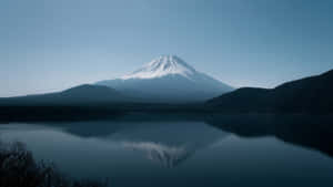 富士山在清澈藍天下倒映在寧靜的湖泊中。