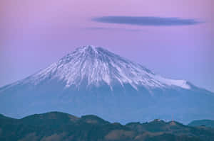 薰衣草色天空下的雪覆蓋富士山，下方是起伏的丘陵。 — 富士山 壁紙