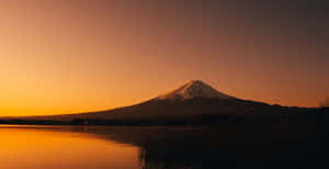 富士山在日落時分倒映在寧靜的湖面上