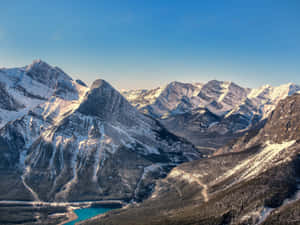 晴朗藍天下，森林山谷中帶有碧綠湖泊的白雪覆蓋山脈。 — 自然風景動圖 壁紙