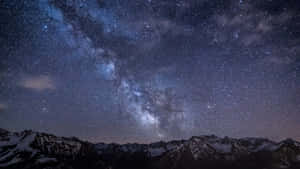 積雪的山脈在充滿活力的星空下，銀河清晰可見。 — 星星 壁紙