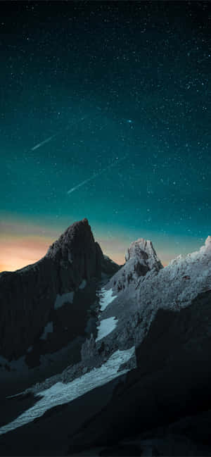 在流星劃過的星空夜空下，白雪覆蓋的山脈。 — 4K iPhone 壁紙