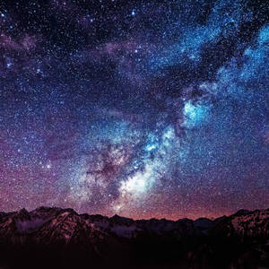 雪覆蓋的山脈在繁星點點的夜空下，銀河系清晰可見。 — 太空 壁紙