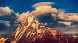 戲劇性日落天空下的白雪覆蓋山峰和透鏡狀雲。 — 山脈 壁紙