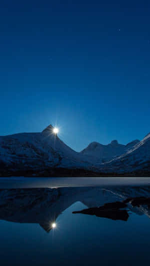 明亮月光下白雪覆蓋的山峰在夜間平靜的湖面上反射。 — 風景 壁紙