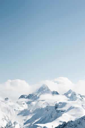 白雪覆蓋的山峰在晴朗的藍天下聳立於雲層之上。 — 美學嬰兒藍 壁紙