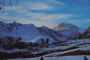 藍天下有滑雪纜車和小建築物的雪山 — 雪景 GIF 壁紙